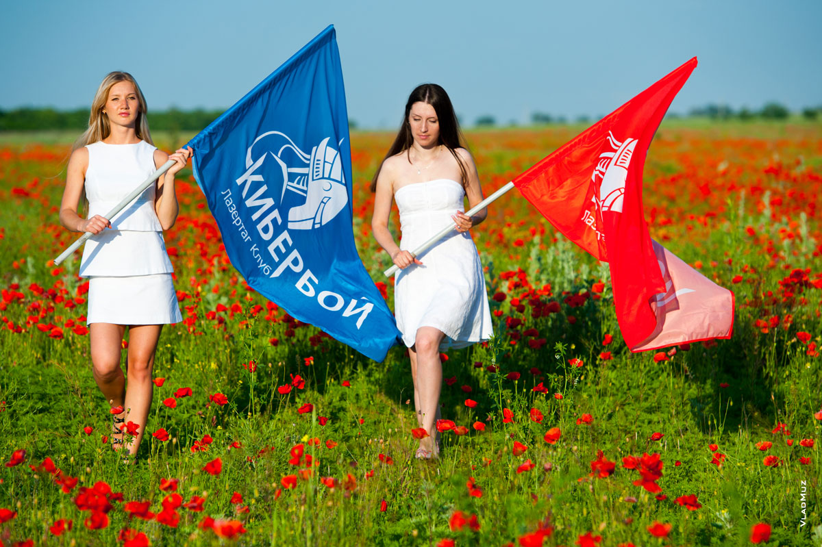 Фото девушек в белых платьях с флагами лазертаг-клуба «Кибербой» на красном маковом поле