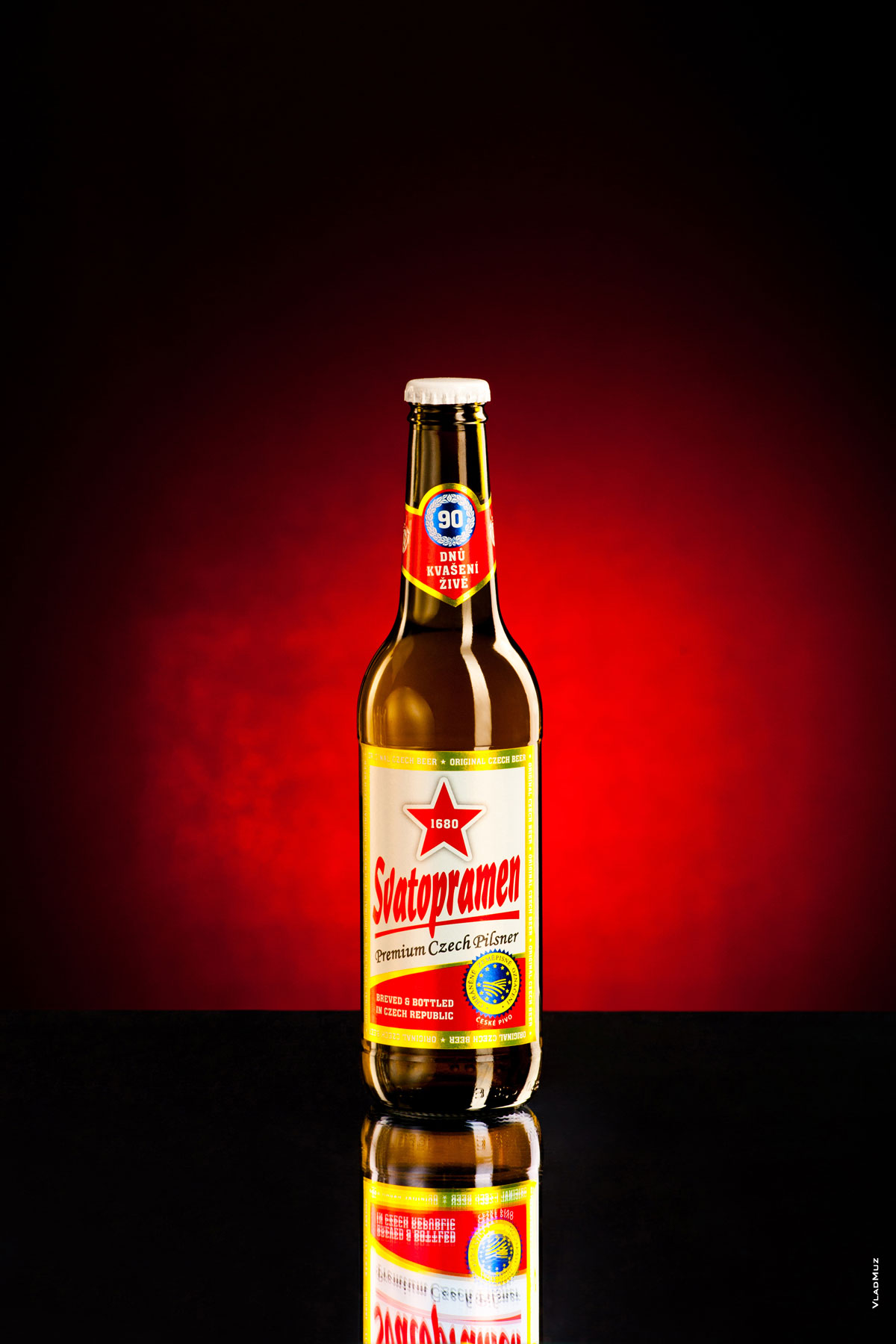 Фото бутылки пива «Святопрамен» в красных тонах