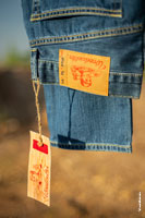 Фото патча на поясе и ярлыка с логотипом  Woodcutter на синих джинсах с избирательной резкостью