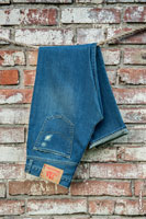 Фото синих джинсовых брюк Woodcutter на фоне кирпичной стены