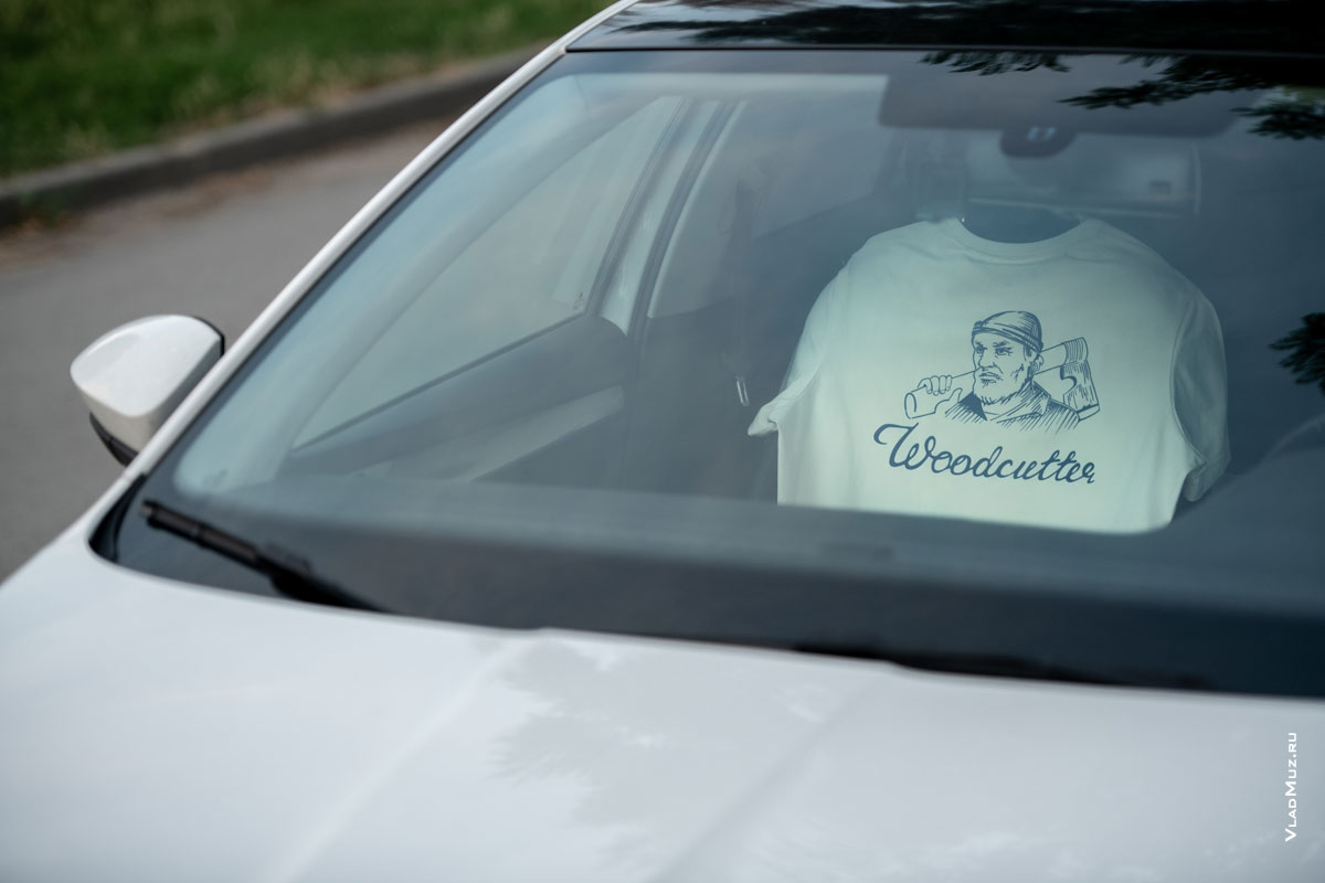 Фото бренда Woodcutter (на футболке на переднем сидении) внутри легкового автомобиля