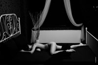 Черно-белая эротическая фотография девушки, лежа в постели