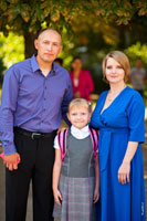 Семейное фото первоклассницы с родителями после 1-го урока
