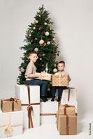 Фото детей с подарками на фоне новогодней елки в студии на белом фоне