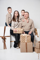 Семейный фотопортрет с детьми на белом фоне с подарками
