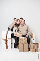 Веселый семейный фотопортрет с детьми в студии на белом фоне с подарками