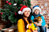 Еще одно парное детское фото девушки и мальчика у новогодней елки с мягкими игрушками
