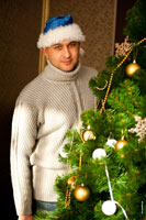 Мужской фотопортрет рядом с новогодней елкой при естественном свете