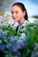 Весенний фото портрет девушки с веснушками среди ветвей сирени