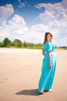 Фото девушки в платье на песчаном пляже в полный рост в уходящей позе