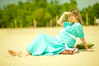 Фото девушки в платье на песке, смотрящей вдаль