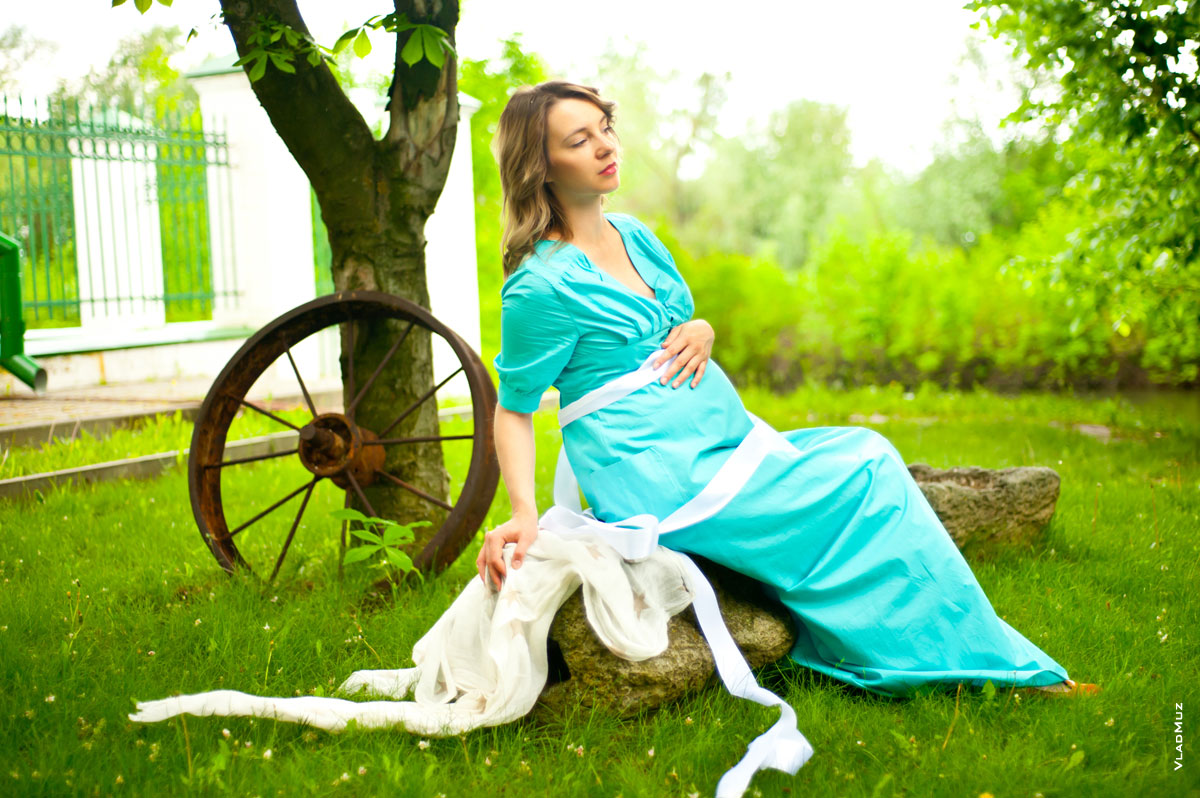 Странная фотография беременной девушки в платье, сидящей на камне с закрытыми глазами