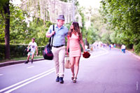 Начало романтической фотосессии: юноша и девушка с цветами идут по дороге парка Горького
