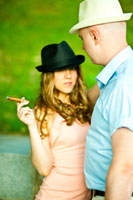 Фото девушки в фетровой шляпе и с сигарой в руке, мужчина рядом