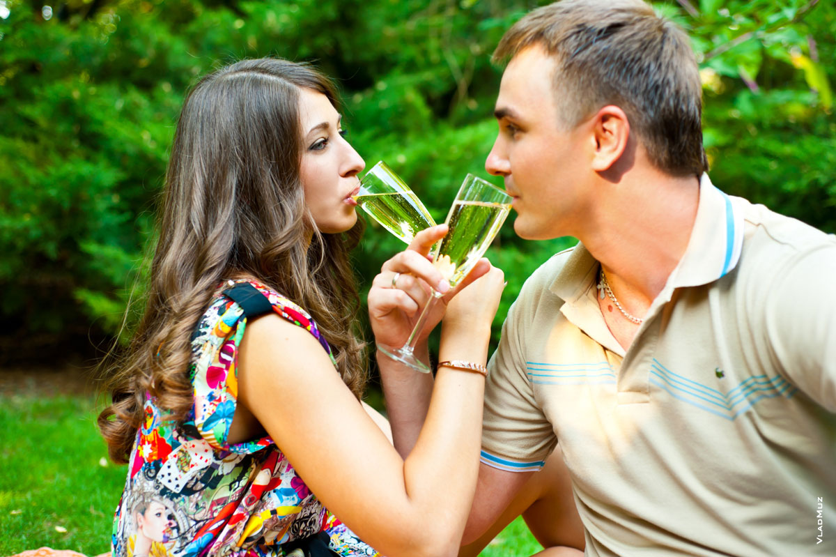 Романтическое фото молодой пары, пьющей шампанское на брудершафт