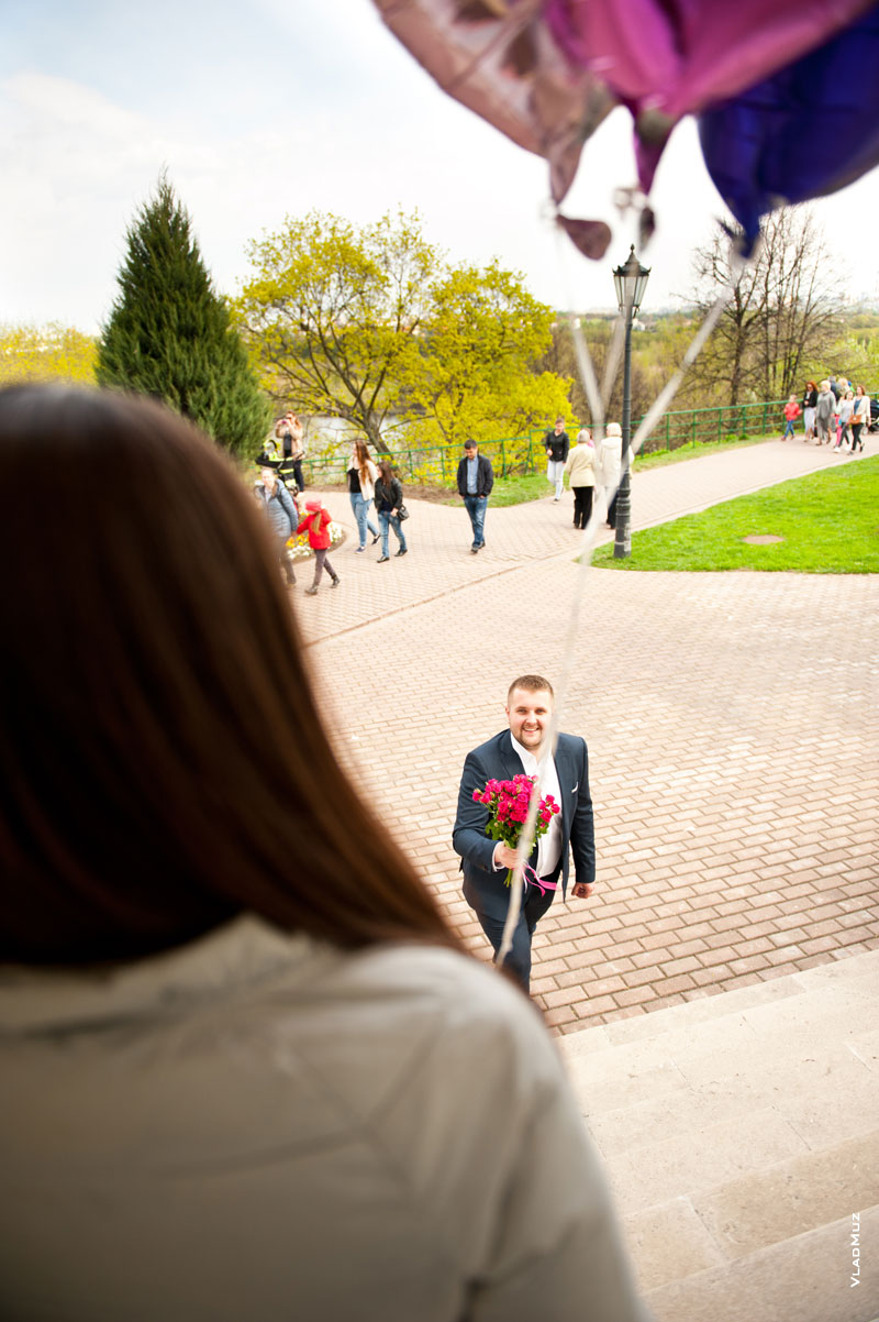 Фото молодого человека с букетом цветов перед девушкой