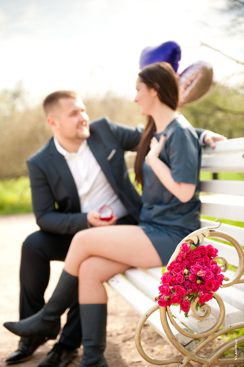 Фото влюбленной пары на лавочке в парке, мужчина делает девушке предложение