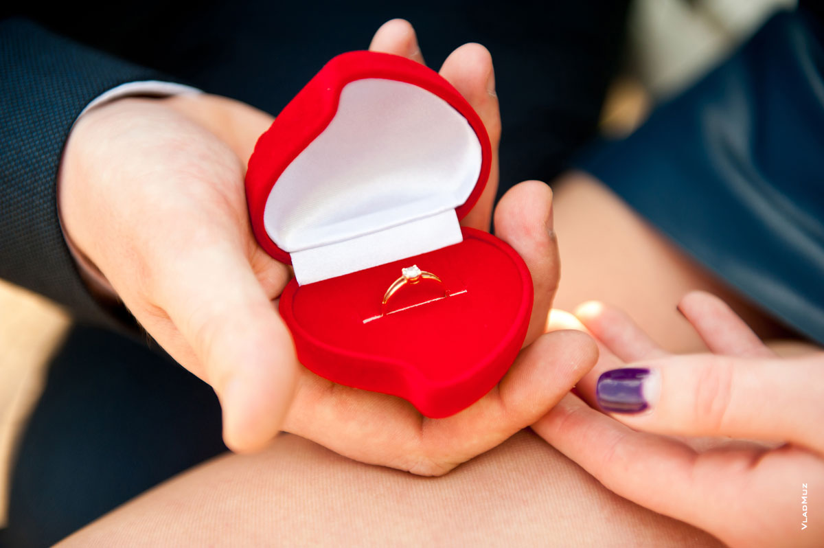 Фото красной коробочки с помолвочным кольцом в ладонях