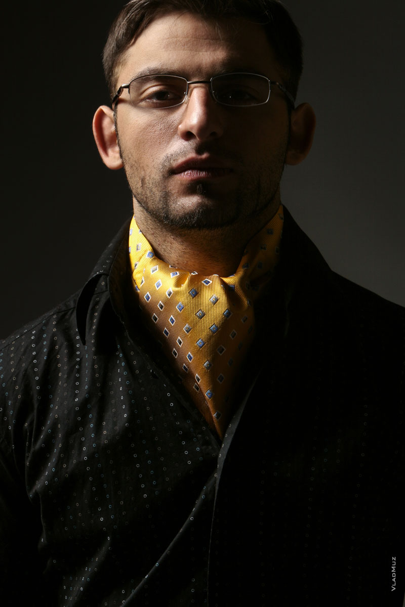 Модный мужской фотопортрет в очках с высокомерным выражением лица