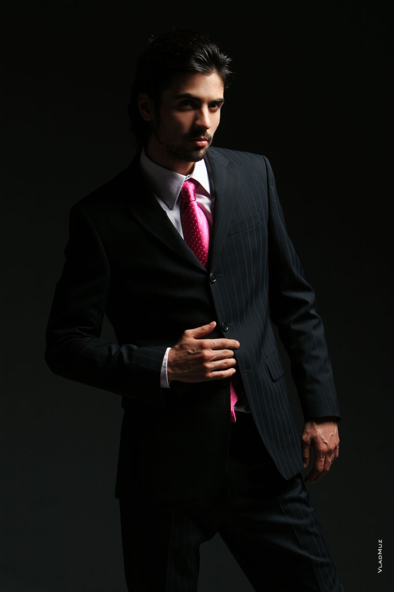 Модная фотография мужчины в костюме с галстуком в темной тональности