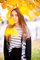 Осенний фотопортрет девушки среди желтых листьев в светлых тонах