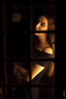 Фотопортрет девушки сквозь застекленную раму телефонной будки