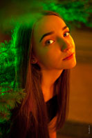 Фото девушки в смешанном цвете: зеленый цвет — от ели, и теплый, красный цвет — от уличных фонарей