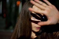 Фото девушки с рукой перед собой и тенью на лице от руки