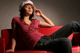 Фото девушки-модели в кепи, сидящей на диване