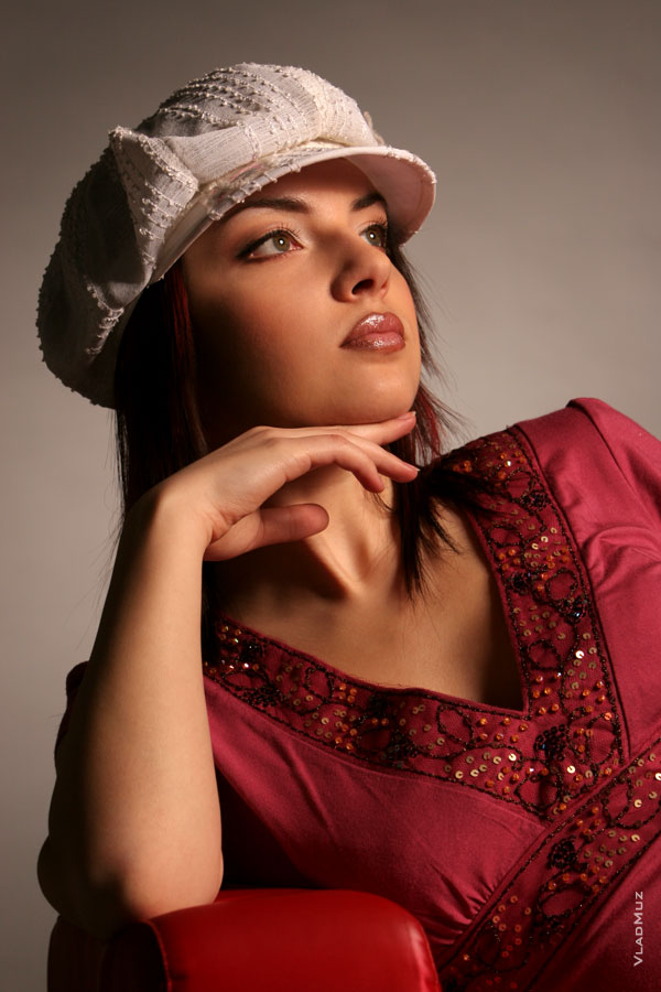 Фото портрет девушки в кепи, с рукой у подбородка