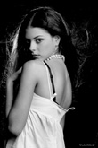 Закрытый полуоборот девушки модели. Черно-белый фотопортрет на черном фоне из портфолио