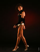 Фотография темнокожей девушки-мулатки в полный рост на черном фоне