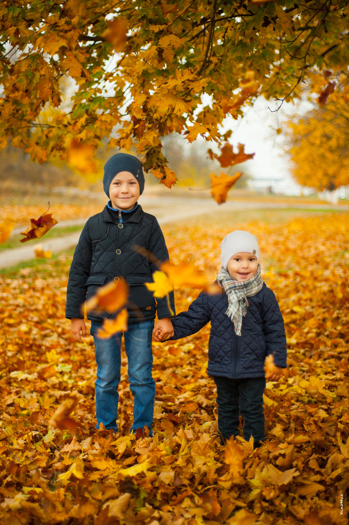 Парный детский фотопортрет в полный рост на желтом фоне из кленовых листьев