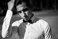 Жанровый черно-белый фотопортрет юноши с рукой у волос