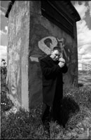 Черно-белый фото портрет мужчины с сигаретой на улице, у стены с граффити