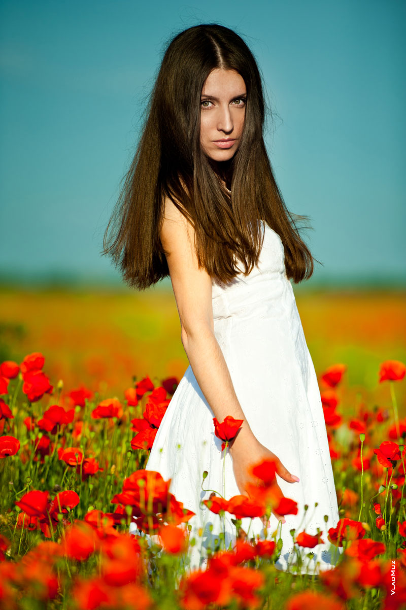 Фотопортрет девушки с красными маками на фоне синего неба