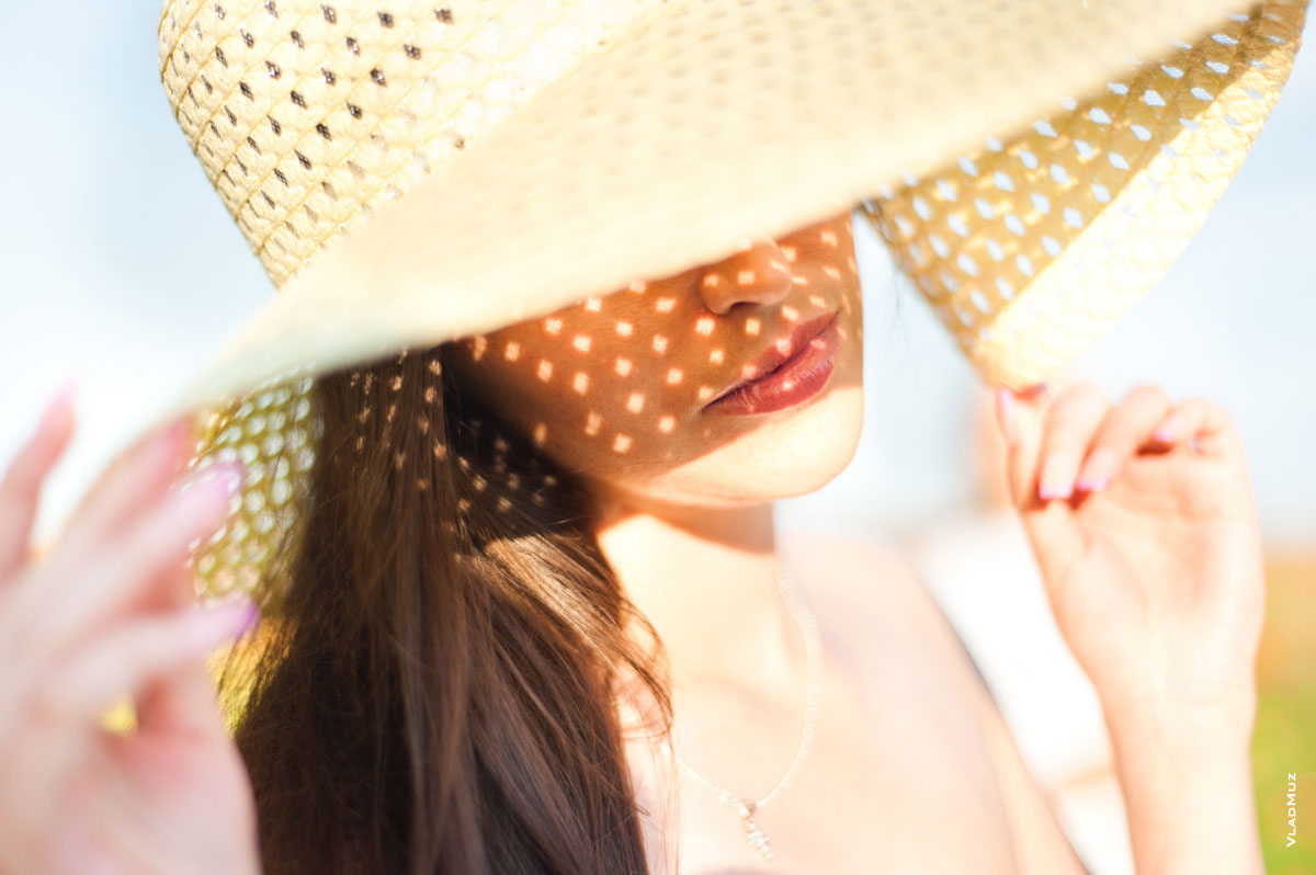 Фото женщины в шляпе с солнечными бликами на лице