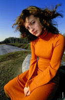 Фотопортрет девушки в оранжевом платье на весеннем пленэре, на фоне синего неба
