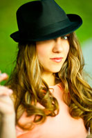Фотопортрет девушки в черной шляпе с акцентом на взгляде