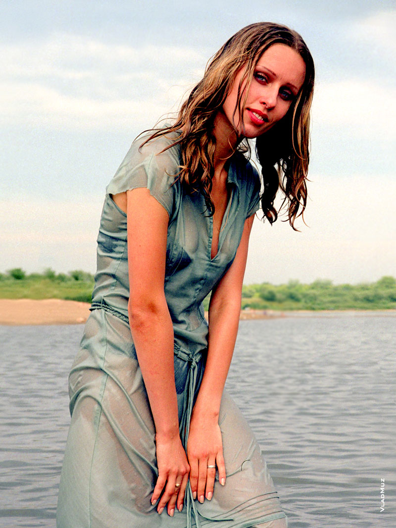 Фотография девушки-модели в мокром платье, стоящей в воде