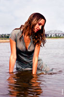 Гламурное фото девушки в мокром платье, сидя в воде