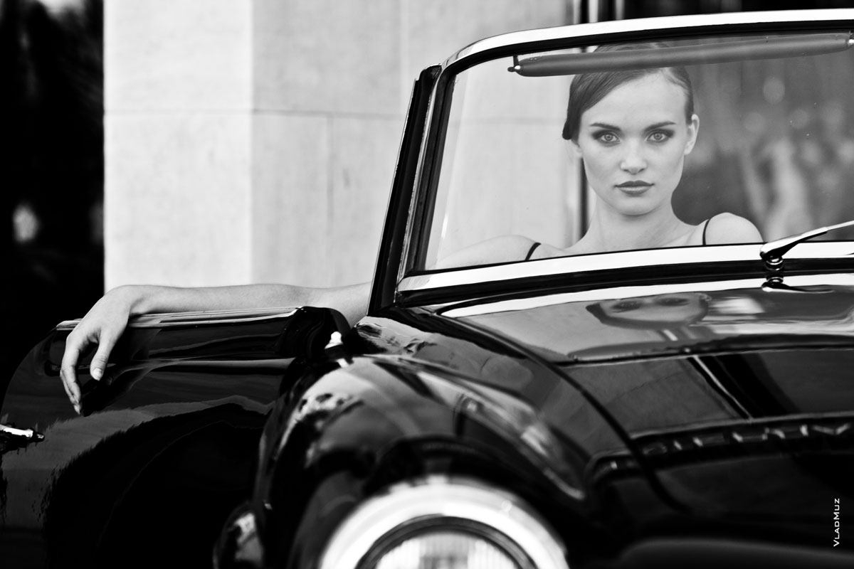 Модный черно-белый женский фотопортрет в старинном кабриолете