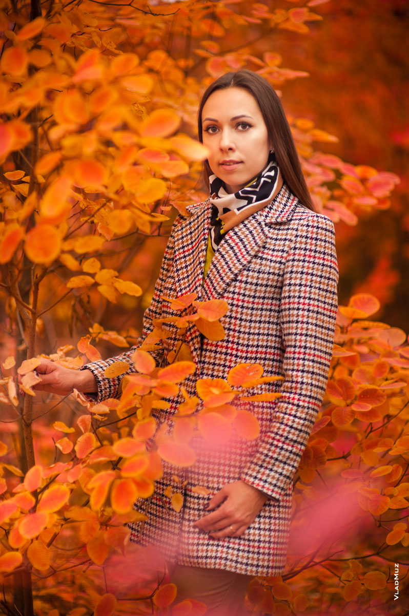 Осенний фотопортрет девушки в пальто, на красно-желтом фоне листвы