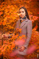 Осенний фотопортрет девушки в пальто, на красно-желтом фоне листвы