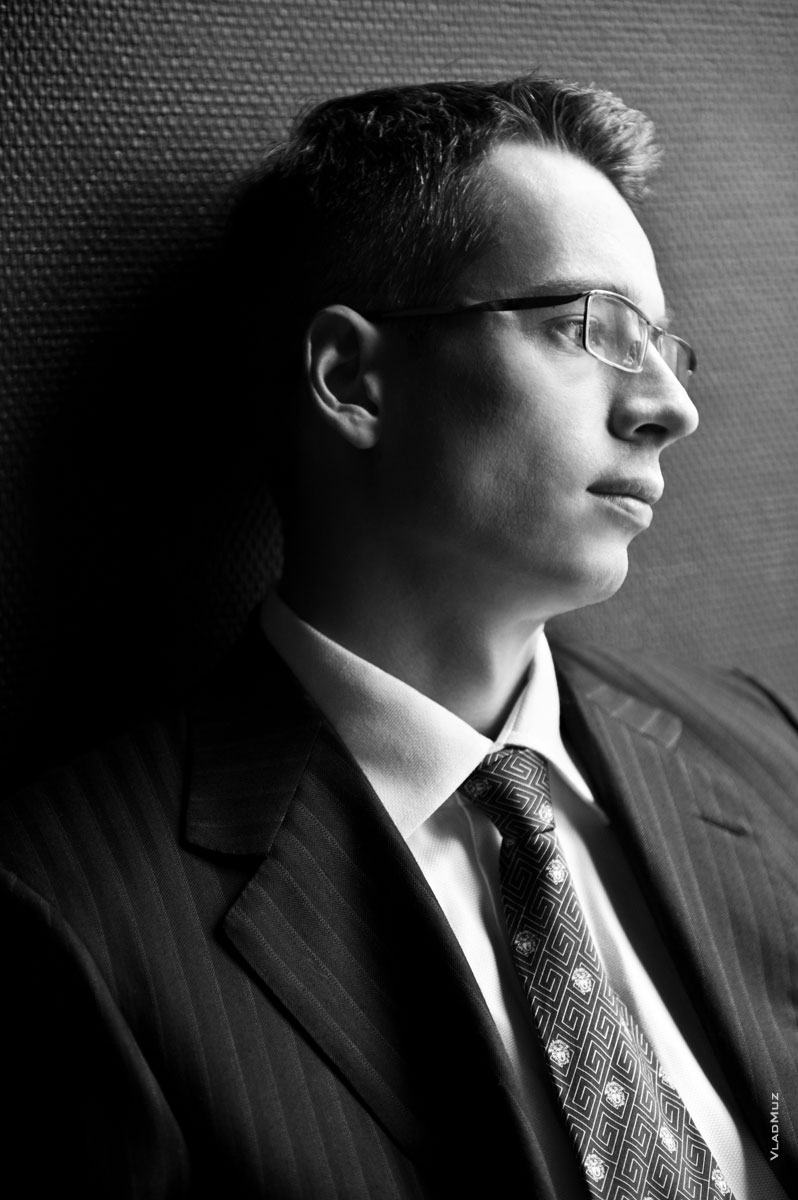 Черно-белое фото делового мужчины в очках, смотрящего в сторону