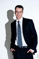 Поясной деловой фото портрет успешного делового человека в костюме, в очках, с жестким светом и с тенью на белом фоне