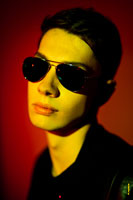 Модный фотопортрет мужчины в солнечных очках в черно-красно-желтых цветах