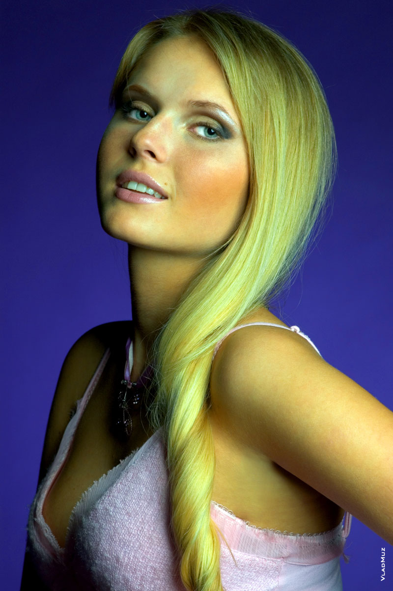 Фотопортрет девушки-блондинки в студии на фиолетовом фоне