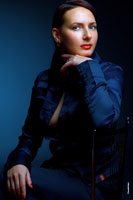 Женский студийный фотопортрет в синих тонах с рукой у лица