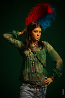 Фотопортрет девушки в студии с яркими перьями на голове